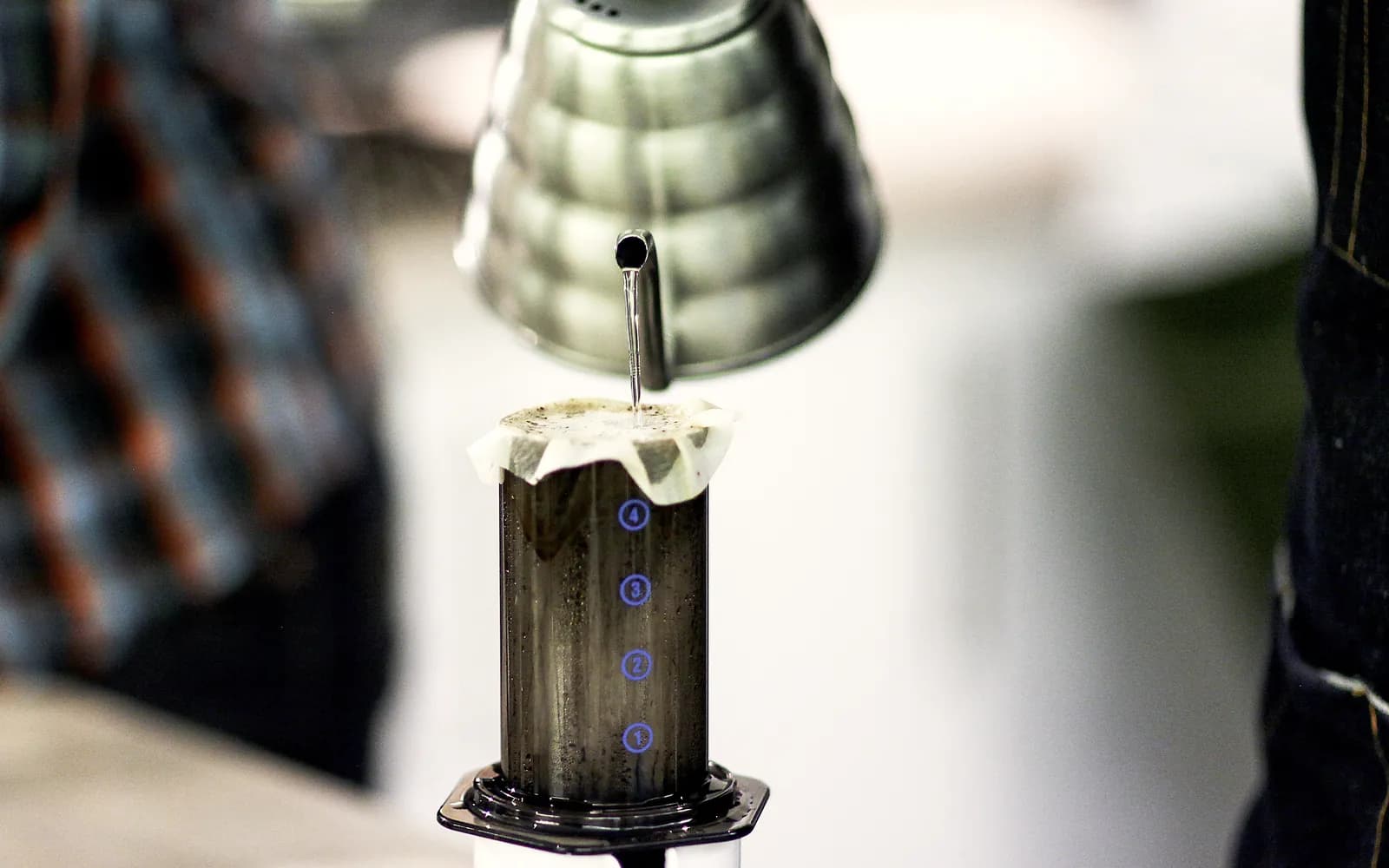 Un AeroPress pe o cană, cu pistonul apăsat